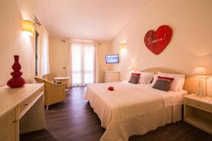 a bedroom with a large bed with a heart on the wall at Albaruja Hotel in Monte Nai