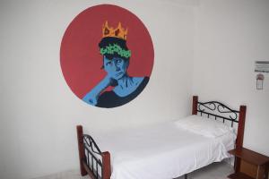 un dormitorio con una pintura de una mujer con una corona en la pared en Deportel Cali, en Cali
