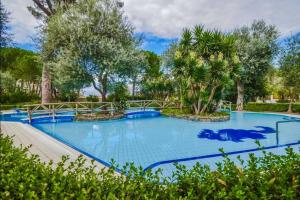 een groot blauw zwembad met bomen en struiken bij Cozy Sorrento Apartment in Sorrento +8 foto's