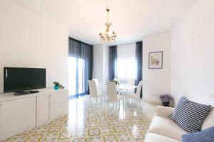een woonkamer met een televisie en een eetkamer bij Cozy Sorrento Apartment in Sorrento