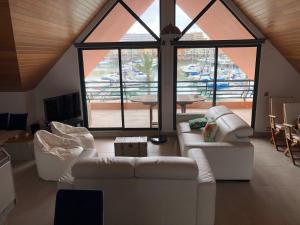 una sala de estar con sofás blancos y una ventana grande. en Beach Apartment Marina Vilamoura en Vilamoura