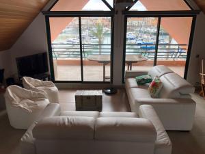ヴィラモウラにあるBeach Apartment Marina Vilamouraのリビングルーム(白い家具、大きな窓付)