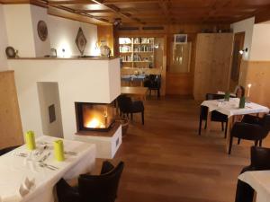 a restaurant with two tables and a fireplace at Pension Ladner in Grundlsee