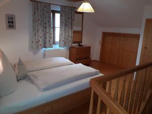 a bedroom with a large bed and a window at Pension Ladner in Grundlsee