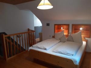 Schlafzimmer mit einem Bett mit einem Kopfteil aus Holz in der Unterkunft Pension Ladner in Grundlsee