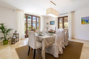 a dining room with a table with white chairs at Finca Son Pol in Andratx
