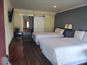 マディソンにあるDeerfield Inn & Suitesのベッドが2つと鏡があるホテルの部屋