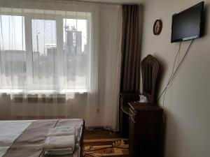 1 dormitorio con 1 cama, TV y ventana en Adina, en Rîşcani