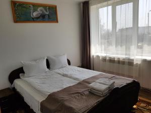 1 dormitorio con 1 cama con 2 toallas en Adina, en Rîşcani