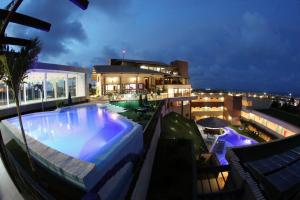 una piscina en la parte superior de un edificio por la noche en Hotel Santuário das Águias en Aquiraz
