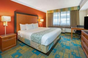 a hotel room with a large bed and a desk at La Quinta by Wyndham Seattle Sea-Tac Airport in SeaTac