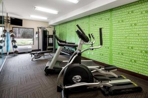 a gym with two tread machines and a green wall at La Quinta by Wyndham LaGrange / I-85 in La Grange