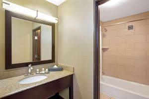 a bathroom with a sink and a mirror at La Quinta Inn & Suites by Wyndham LV Tropicana Stadium in Las Vegas