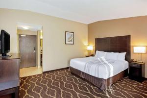 a hotel room with a bed and a television at La Quinta Inn & Suites by Wyndham LV Tropicana Stadium in Las Vegas