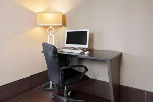 a desk with a computer and a lamp on it at La Quinta Inn & Suites by Wyndham LV Tropicana Stadium in Las Vegas