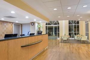 an office lobby with a reception desk and a table at La Quinta Inn & Suites by Wyndham Sunrise in Sunrise +23 photos