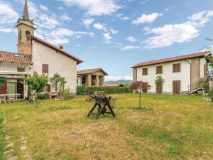 a church and a picnic table in a field next to a building at Rustic Holiday Home in Montemarzino with Garden in Casasco