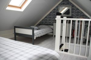een zolderkamer met een bed en een trap bij B&B De Voort Venlo in Venlo