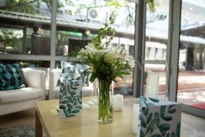 un jarrón lleno de flores blancas en una mesa en Summit Villa, en Chişinău