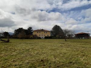 a large field with a house in the background at Hotel Hontoria in Hontoria