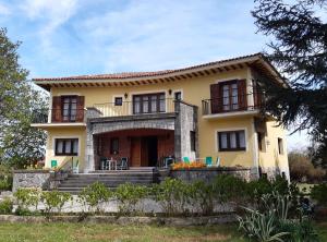 a large yellow house with stairs in front of it at Hotel Hontoria in Hontoria