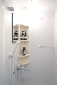 W łazience znajduje się prysznic z butelką alkoholu. w obiekcie Blue Empire Hotel w Tokio