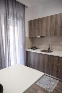德拉瑪的住宿－Apartment One，厨房配有木制橱柜、水槽和窗户。