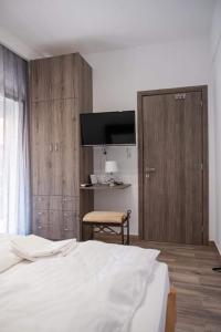 una camera con un letto bianco e una porta in legno di Apartment One a Drama