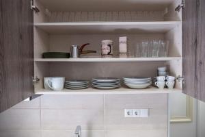 a cupboard filled with plates and cups and dishes at Apartment One in Drama