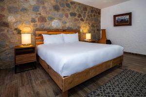 1 dormitorio con 1 cama grande y 2 lámparas en las mesas en Hotel Boutique Camino Del Bosque by Rotamundos, en Cholula