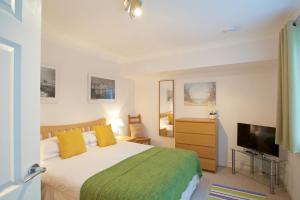 a bedroom with a bed and a flat screen tv at Beach View in St Ives