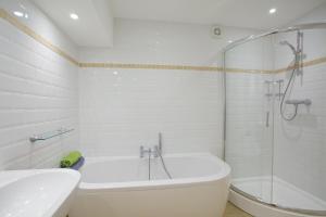 a bathroom with a tub and a sink and a shower at Beach View in St Ives +15 photos
