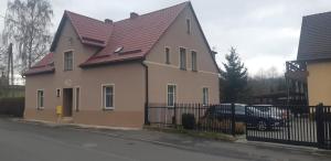 une maison avec une voiture garée devant elle dans l'établissement Nad Kamienną, à Jelenia Góra