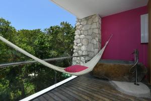 a hammock on the balcony of a house at Hotel Xcaret Mexico All Parks All Fun Inclusive in Playa del Carmen
