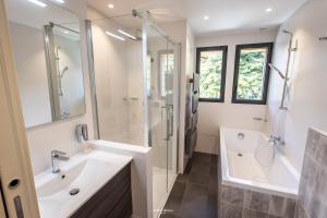 een badkamer met een wastafel, een douche en een bad bij Chalet Hygge Saint Lary - ressourcez-vous dans les Pyrénées in Saint-Lary-Soulan