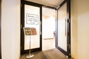 an open door with a sign on the wall at Dormy Inn Express Mikawaanjo in Anjomachi
