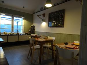a dining room with a table and chairs and a kitchen at Auberge BonBeauJoli in Saint-Jean-de-Monts