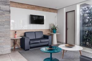 a living room with a couch and a table at Citi Hotel Express Caruaru in Caruaru