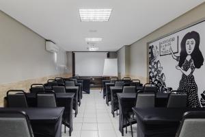 an empty lecture room with black chairs and a whiteboard at Citi Hotel Residence Caruaru in Caruaru
