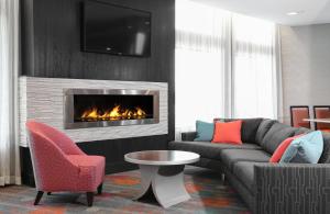 uma sala de estar com um sofá e uma lareira em Holiday Inn Express Moline - Quad Cities Area, an IHG Hotel em Moline
