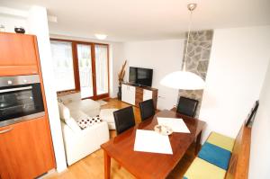 a kitchen and living room with a table and chairs at Pierta Apartment in Bovec