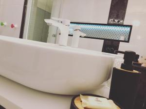 La salle de bains est pourvue d'un lavabo et d'un miroir. dans l'établissement Art Apartament, à Zielona Góra