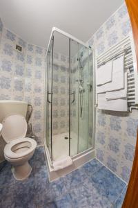 a bathroom with a toilet and a shower with towels at HOTEL HO2 POIANA MARULUI in Poiana Mărului