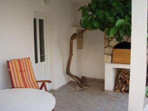 a table and a chair in a room with a fireplace at Apartment Neva - 30 m from sea in Zavala