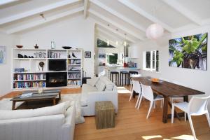 a living room with a table and a dining room at Cape Cottage in Oneroa
