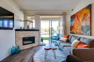 sala de estar con sofá y chimenea en Tranquil Waterfront Condo, en Kelowna