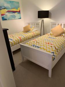 a bedroom with two beds and a lamp at Tranquil Waterfront Condo in Kelowna +12 photos