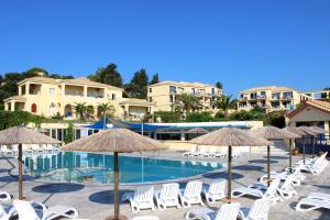 a swimming pool with chairs and umbrellas at Ionian Sea View Hotel - Corfu in Kavos