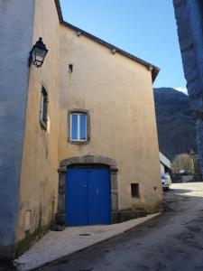 a building with a blue door on the side of it at Appartements "Le Casino" et "Lou petit" in Laruns