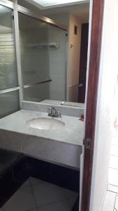 a bathroom with a sink and a mirror at Hotel Pez Vela in Manzanillo